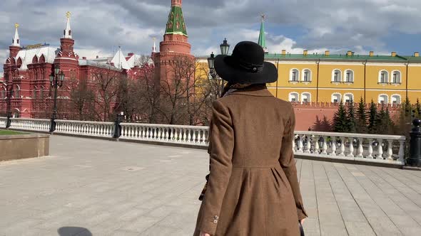 Elegant woman in hat walking on Red Square near Historical Museum, Kremlin, Red Square Moscow Russia
