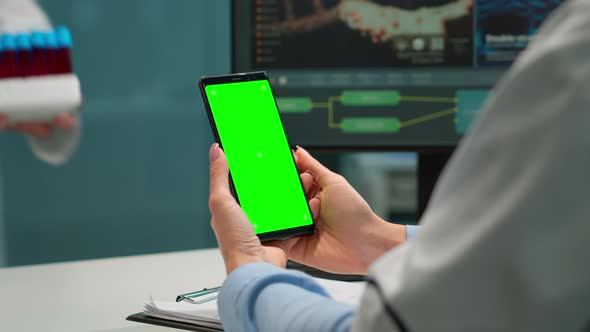 Medic in Scientific Laboratory Holding Phone with Green Screen