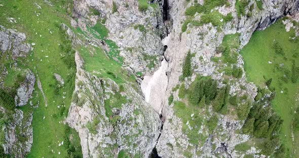 Top View of Steep Mountain Cliffs and an Ice Cave