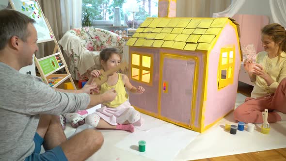 Father Gives Happy Little Girl a Key To Her New Cardboard House.