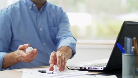 Man Using Hand Sanitizer at Home Office