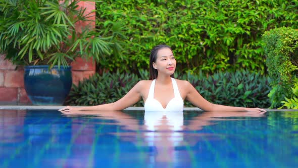 Young asian woman enjoy around outdoor swimming pool for leisure