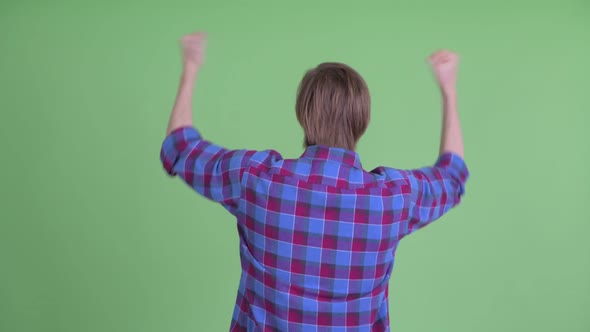 Rear View of Happy Young Hipster Man with Fists Raised