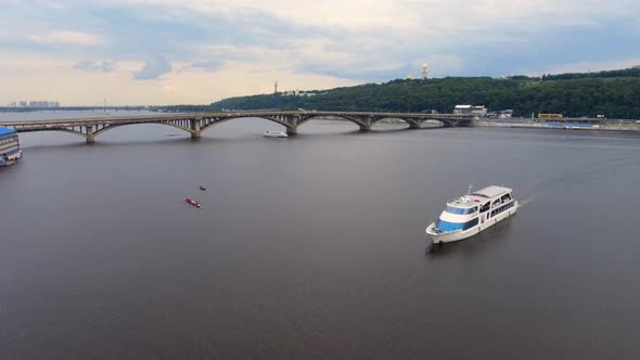 Passenger Ship Sails along City River