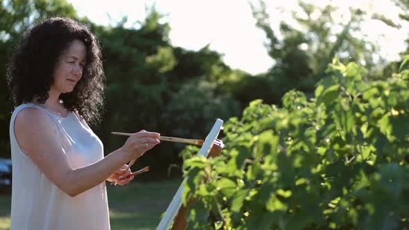 Female Artist Painting a Colorful Painting Outdoors
