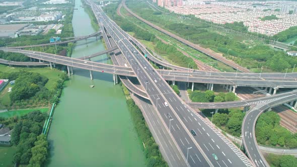 Aerial Orbital View of a Highway Overpass Multilevel Junction with Fast Moving Cars Surrounded By