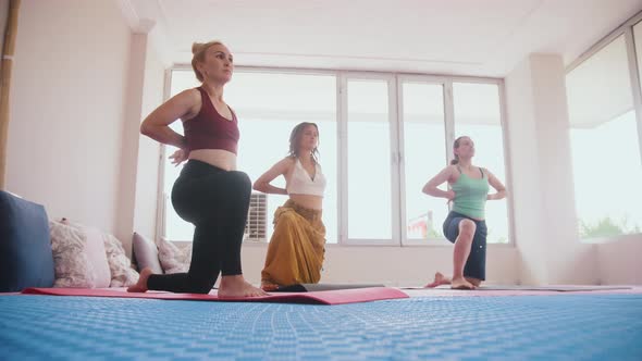 Three Women Standing on Yoga Mats on Their Knees and Doing the Exercises in the Studio