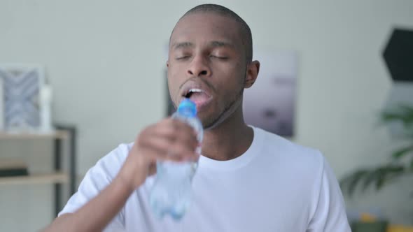 Close Up of Athletic African Man Drinking Water at Home