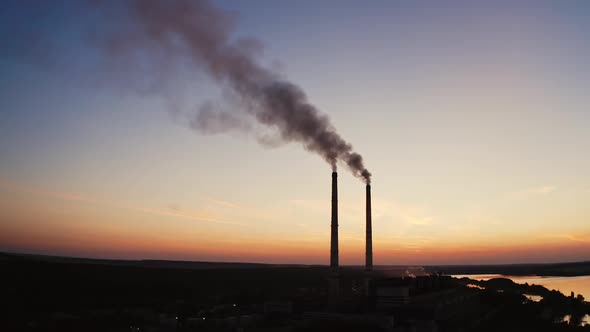 Dirty smoke from industrial pipes over the clear evening sky. 