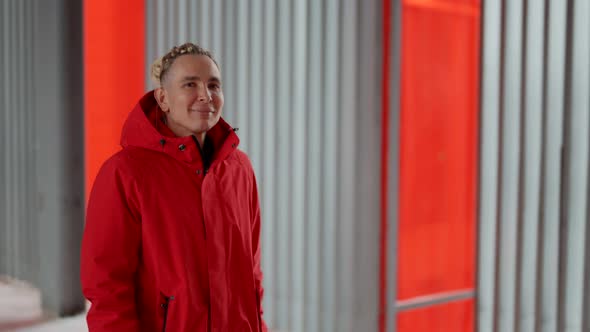 a Handsome Gay Man in a Red Warm Jacket Walks Around a Modern City in Winter