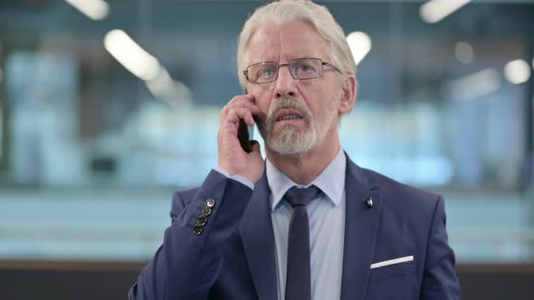 Portrait of Old Businessman Talking on Phone