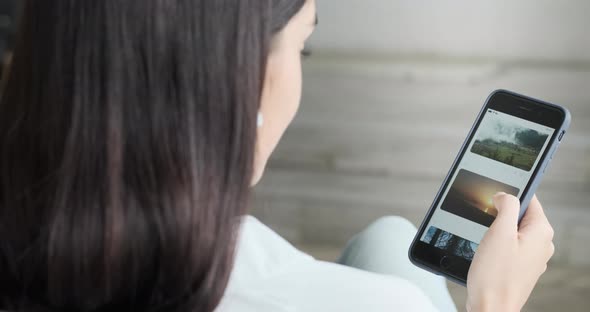 Young Woman Using Smartphone Scrolling Through Social Network Feed Doing Swiping