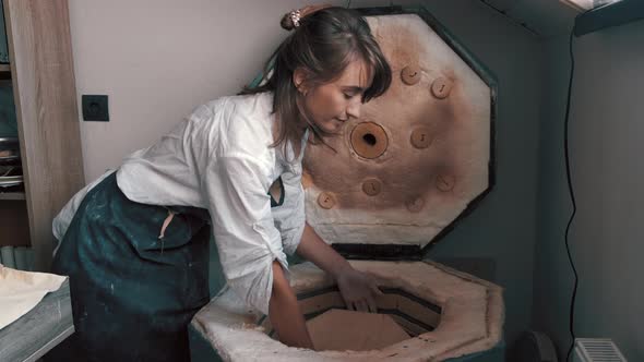 Potter Preparing the Pottery Kiln for the Baking Process for Her Dish