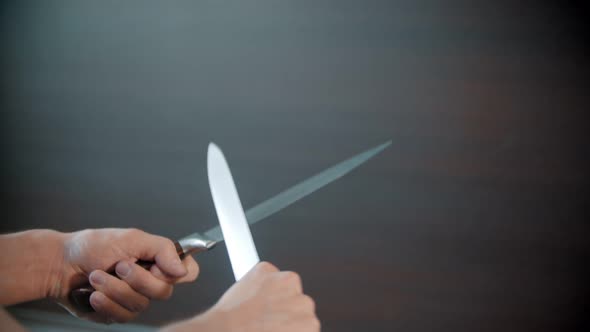 A Person Sharpening Knives Between Each Other