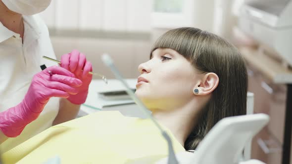 A Dentist Is Treating a Patient's Teeth with Instruments