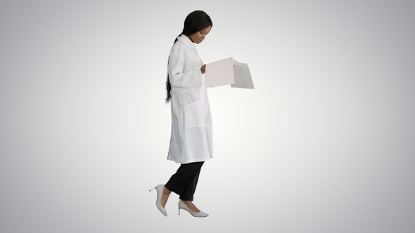 Afro American Doctor Woman Walking and Looking at Cardiogram