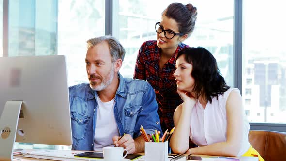 Group of graphic designers working together at desk