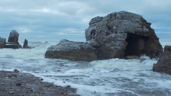 Big stormy waves breaking against abandoned seaside fortification building ruins at Karosta Northern