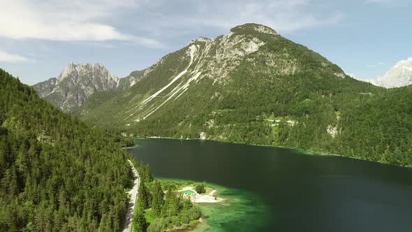 Aerial view of Lago del Predil lake surrounded by hills in Itally.