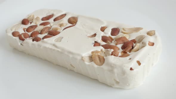 Nougat halva with almonds on white 4K video