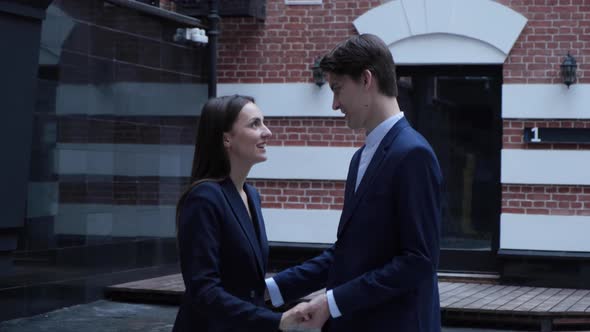 Two entrepreneurs smiling and talking. Male and female cheerful business people communicating 