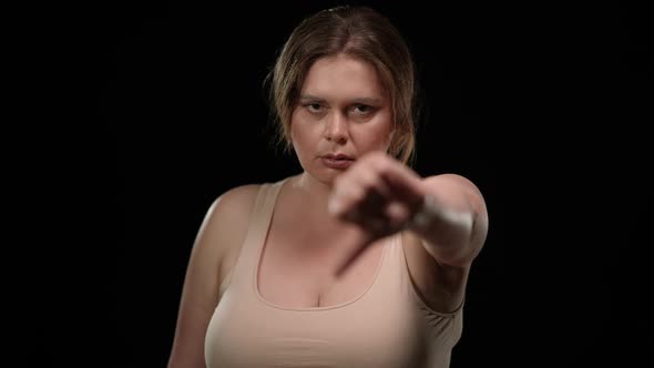 Dissatisfied Caucasian Plus Size Woman Gesturing Thumb Down Looking at Camera