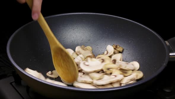 Mushrooms and Chicken Fillets are Fried in a Wok Pan