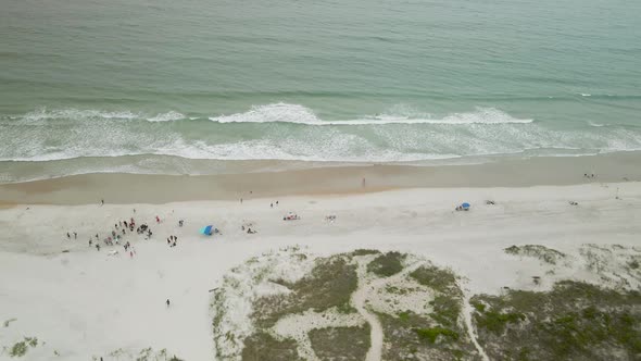 Waves lapping in front of Shell Island Resort Aerial tracking toward sea