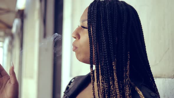 hispanic young woman smoking a cigarette waiting for someone