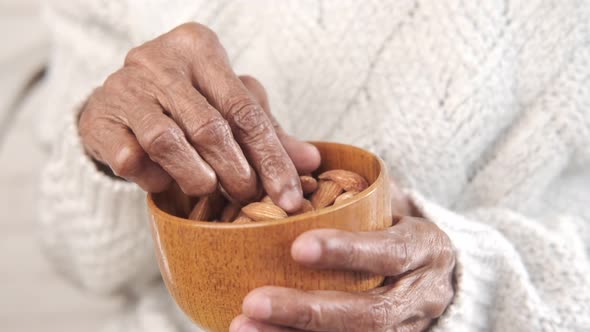 Close Up Senior Women Hand Holding a Bowl on Almond