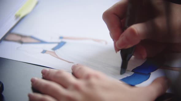 Young Woman Drawing Dress Design Using a Marker