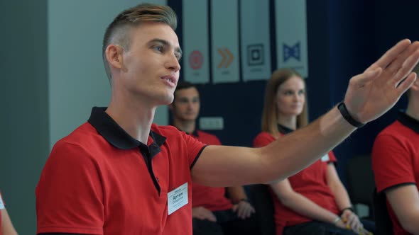 Young guy asks a question of a speaker during a continuing education lecture at a mall job