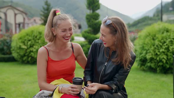 Best Friends Women are Chatting and Laughing in Park Drink Coffee and Smoke Cigarettes