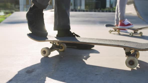 Low section of caucasian man and woman skateboarding at a skatepark