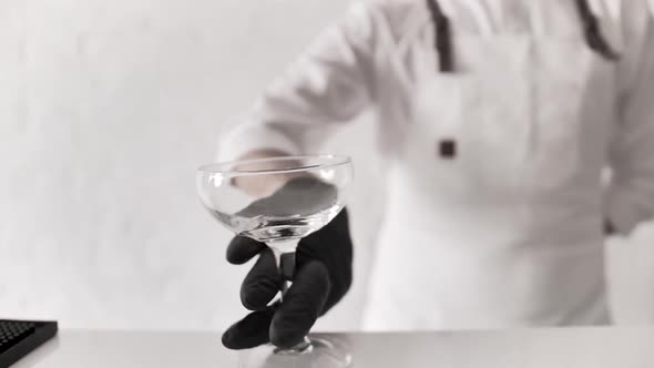 Bartender Mixologist Puts Empty Cocktail Glass on Bar Counter