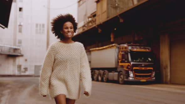 Smiling Young Woman With Afro Hair Walking Passed