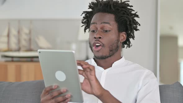 Portrait of African Man Having Success on Tablet