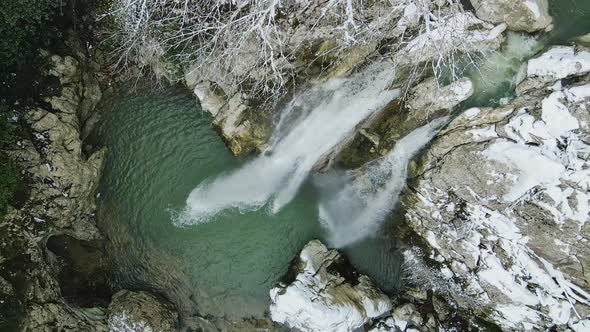 Waterfall Flowing From White Rocks Into a Lake in the Forest