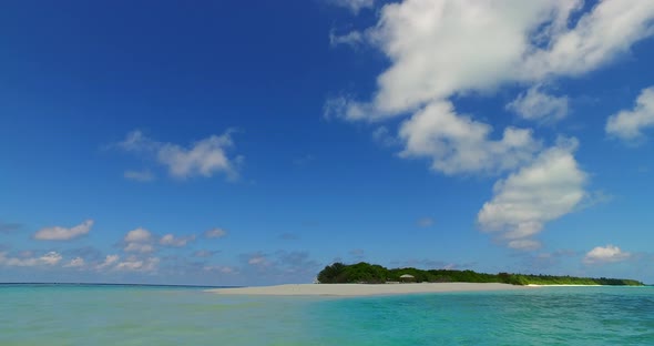 Beautiful fly over clean view of a white paradise beach and aqua blue water background in vibrant 4K