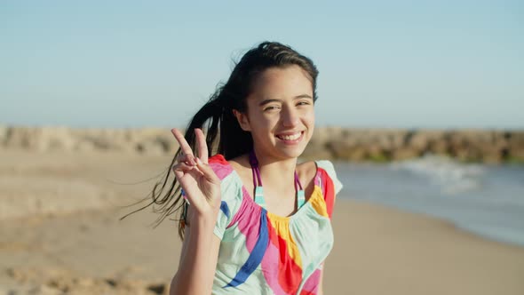 Medium Shot of Pretty Smiling Teenage Girl Sitting on Beach