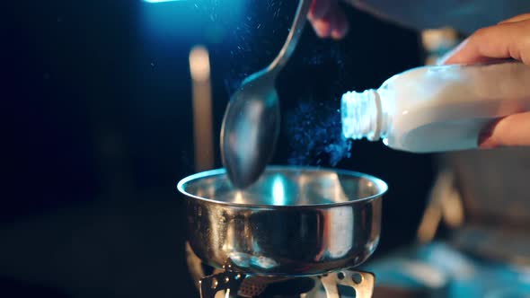 Young man preparing a drugs. Man holds a spoon over a cigarette lighter.