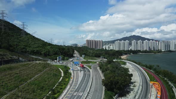 A tilt up shot of the highway in Tuen Mun where cars are seen passing by. Along with that there is a