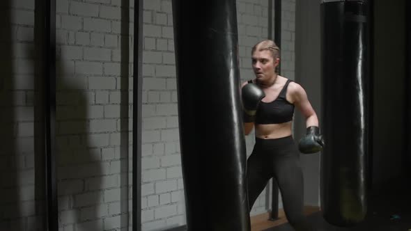 Kickboxing Sporty Woman Fighter Trains His Punches and Kicks Beats a Punching Bag Training Day in