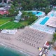 Flight Over the Beach with Umbrellas Towards the Pool in a Luxury Hotel - VideoHive Item for Sale