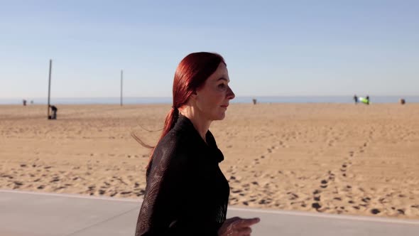 Mature Woman Exercising At The  Beach