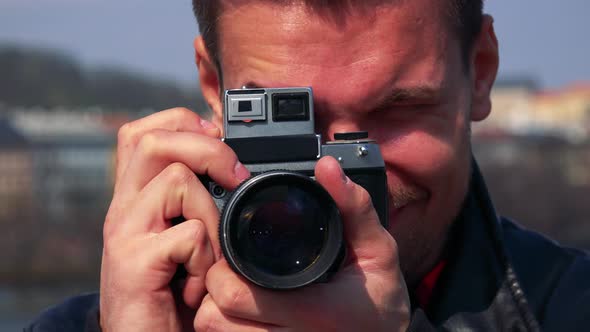 A Young Handsome Man Takes a Photo of the Camera with His Own Camera and Smiles - Face Closeup