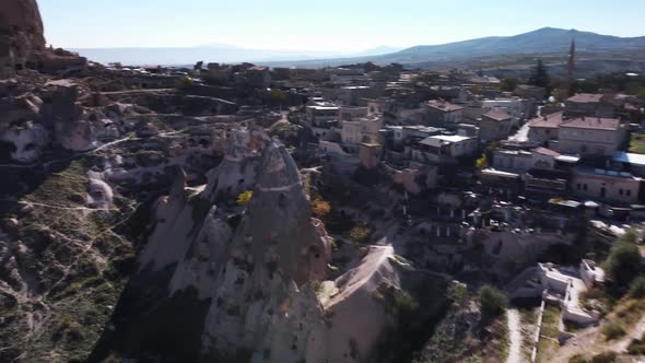 Uchisar Cave Town with Cone Shaped Cliff in the Middle is Filmed By Drone at Hot Summer Day