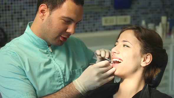 Close up of girl in dental chair shows with finger aching tooth
