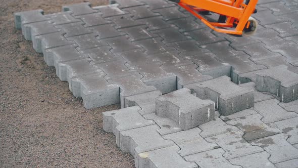 The machine installs the grey pavement.Close-up video.