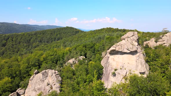 Aerial View of Bright Landscape with Green Forest Trees and Big Rocky Boulders Between Dense Woods